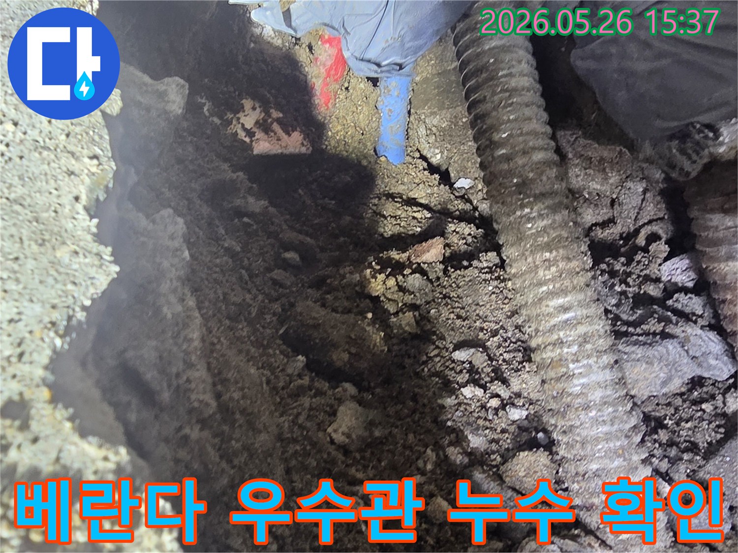 누수-탐지-전문가가-아파트-베란다-우수관의-누수-지점을-정확히-확인하기-위해-좁은-공간에서-굴착-작업을-진행하는-모습입니다.