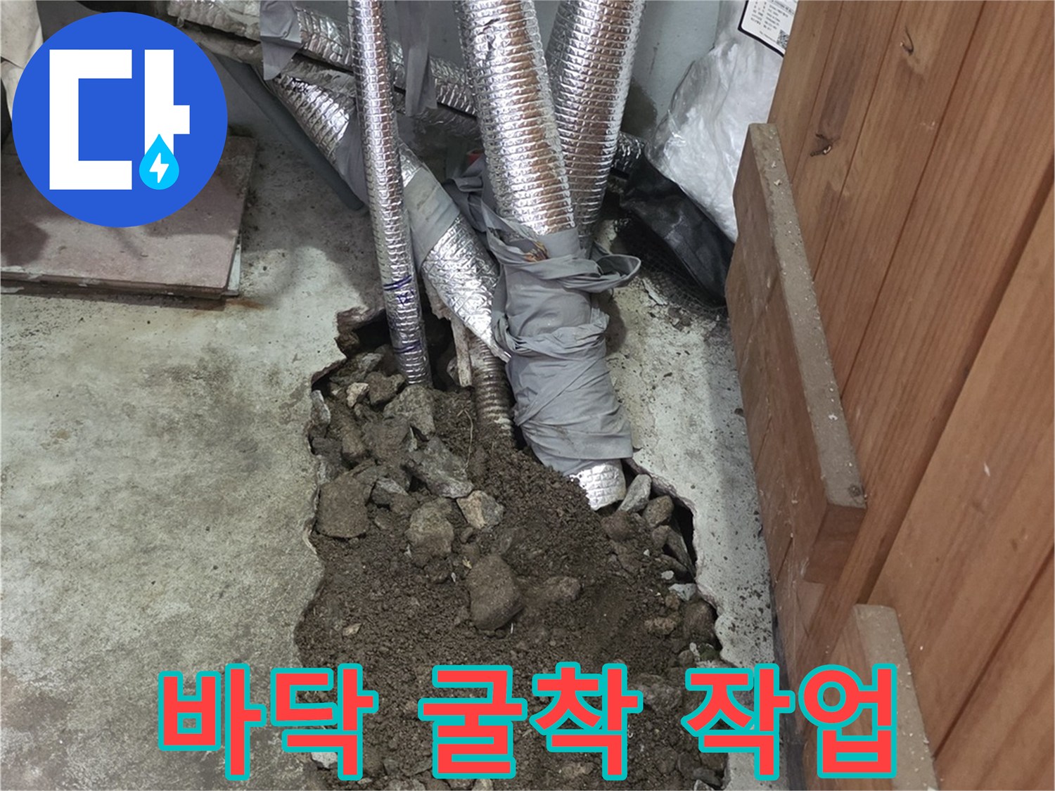 콘크리트를 파내어 배관을 드러낸 공사 현장 사진입니다.