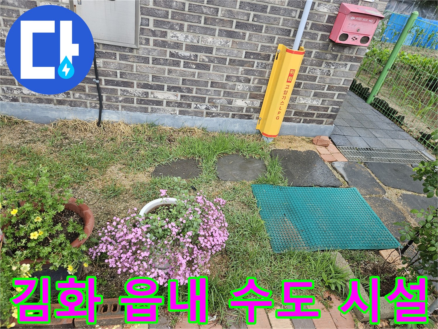 벽돌 벽체와 외부 수도 장치가 설치된 마당의 전경입니다.