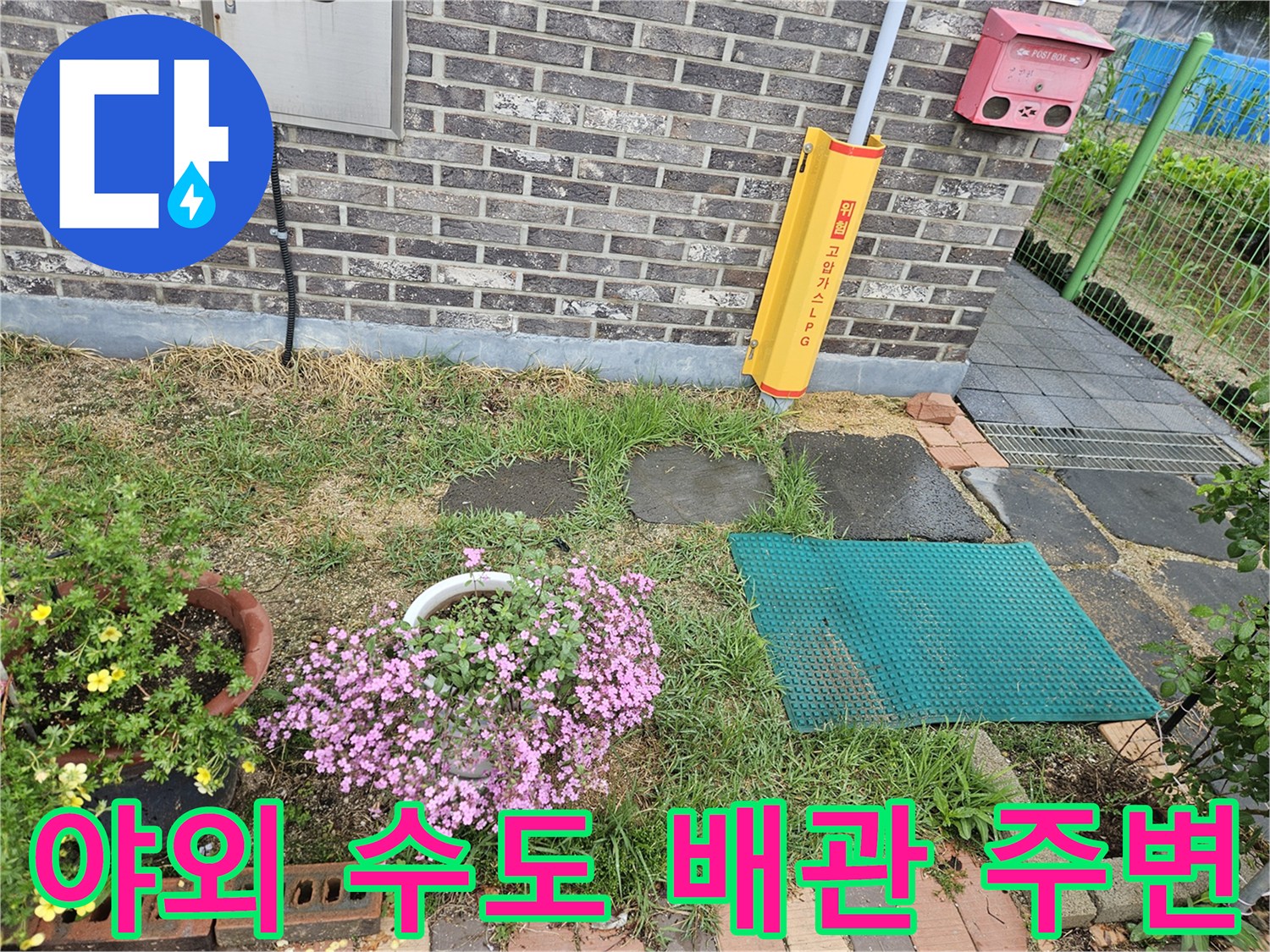 외부 수도 시설이 설치된 마당의 벽돌 담장과 지면 모습입니다.