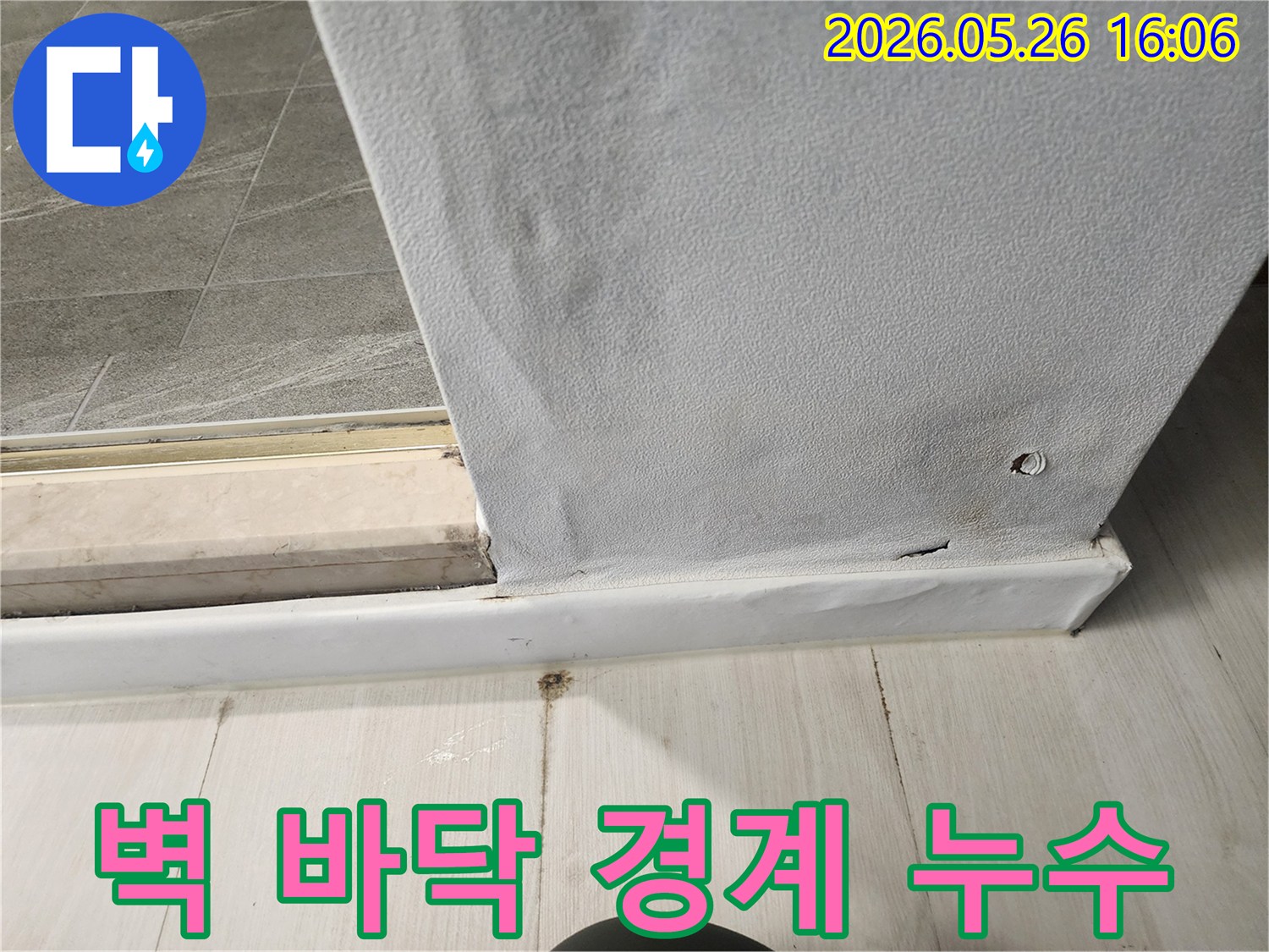 문틀-아래-벽면과-걸레받이에-물이-스며들어-변색된-누수-현장-사진
