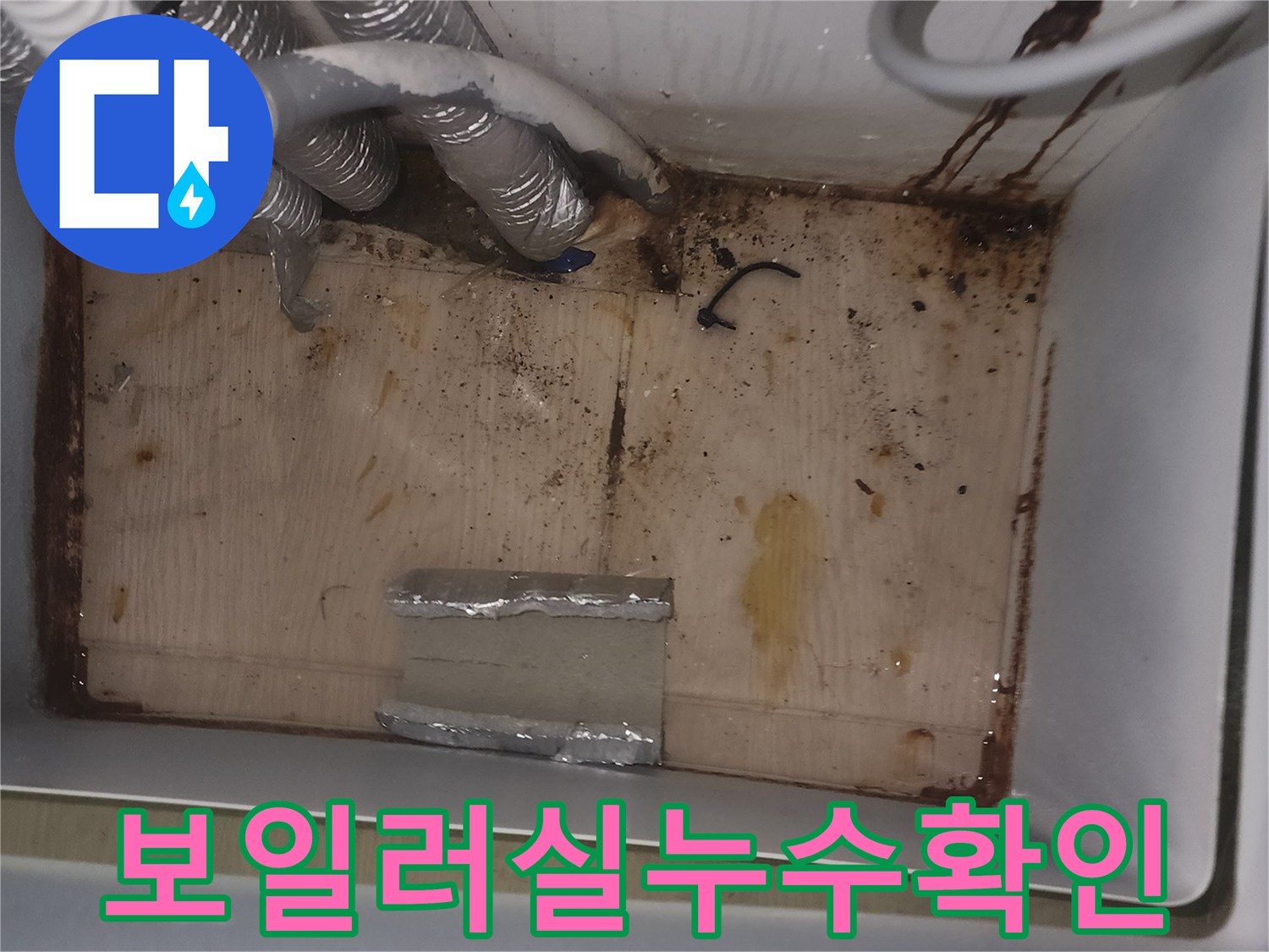 보일러실 바닥과 벽면에 물이 새어-오염된 흔적과 함께-누수 원인을 파악하기 위한 현장 이미지입니다