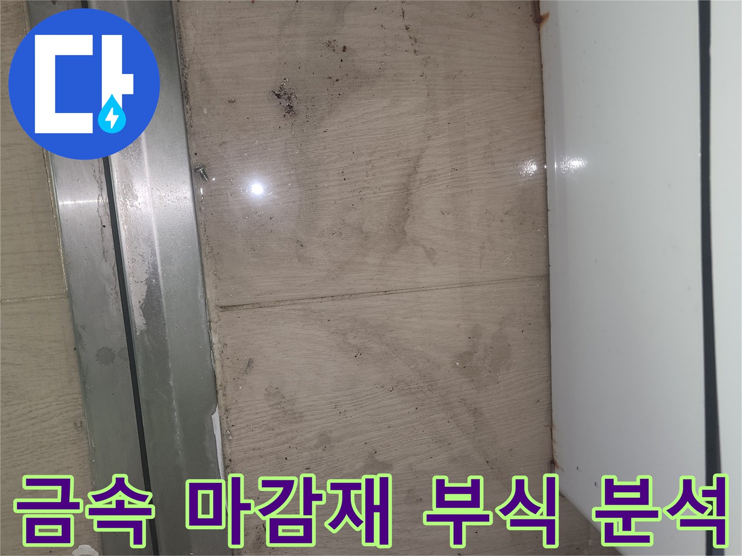 이 사진은 봉담 푸르지오 아파트 바닥의 금속 마감재 부식과 물고임 흔적을 보여주며-누수 원인 분석이 시급합니다