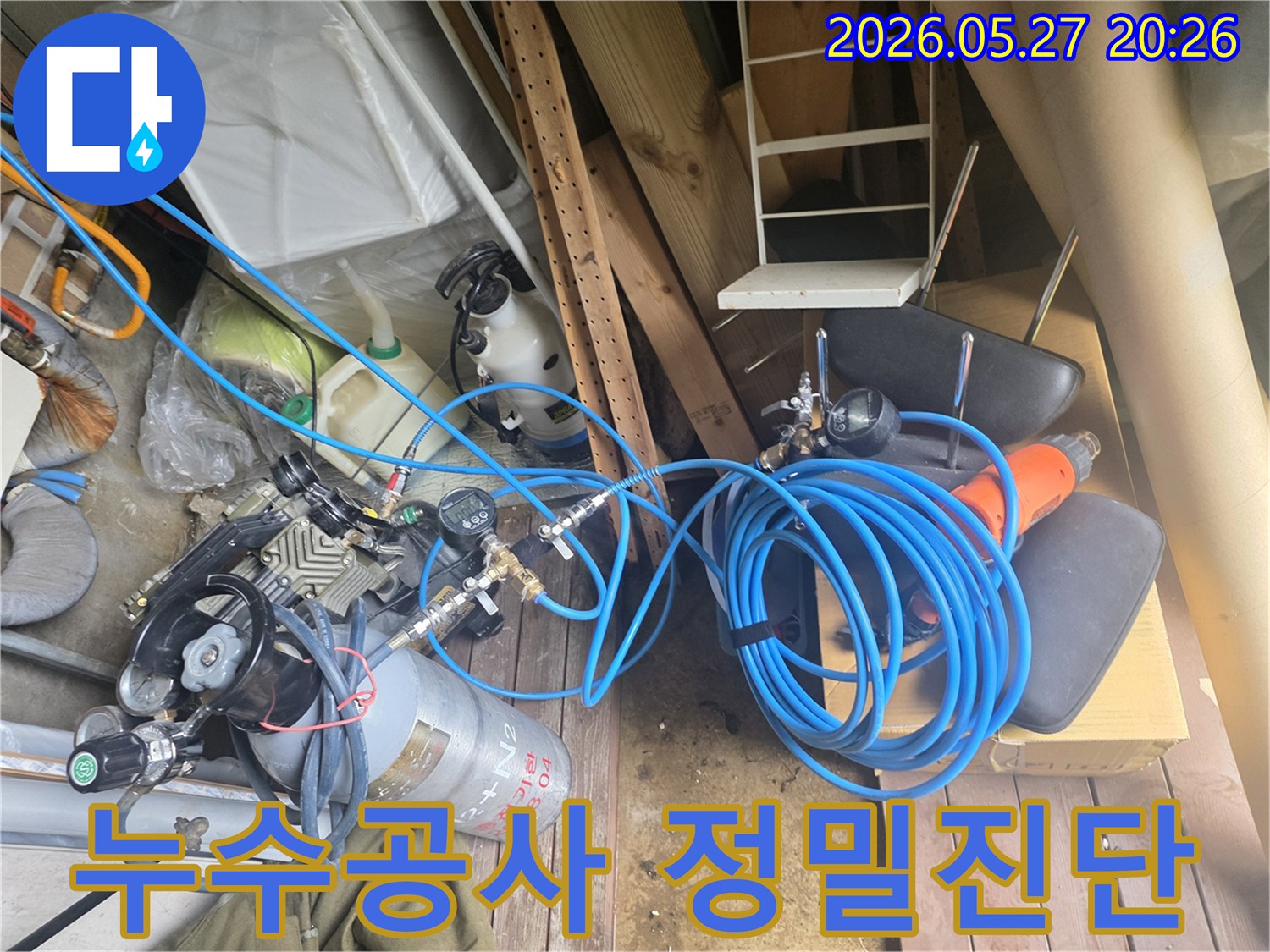 누수 수리를 위한 정밀 진단 과정에 사용되는 압력 측정 장비와 가스 실린더-그리고 연결된 호스들이 현장에 준비된 모습입니다.