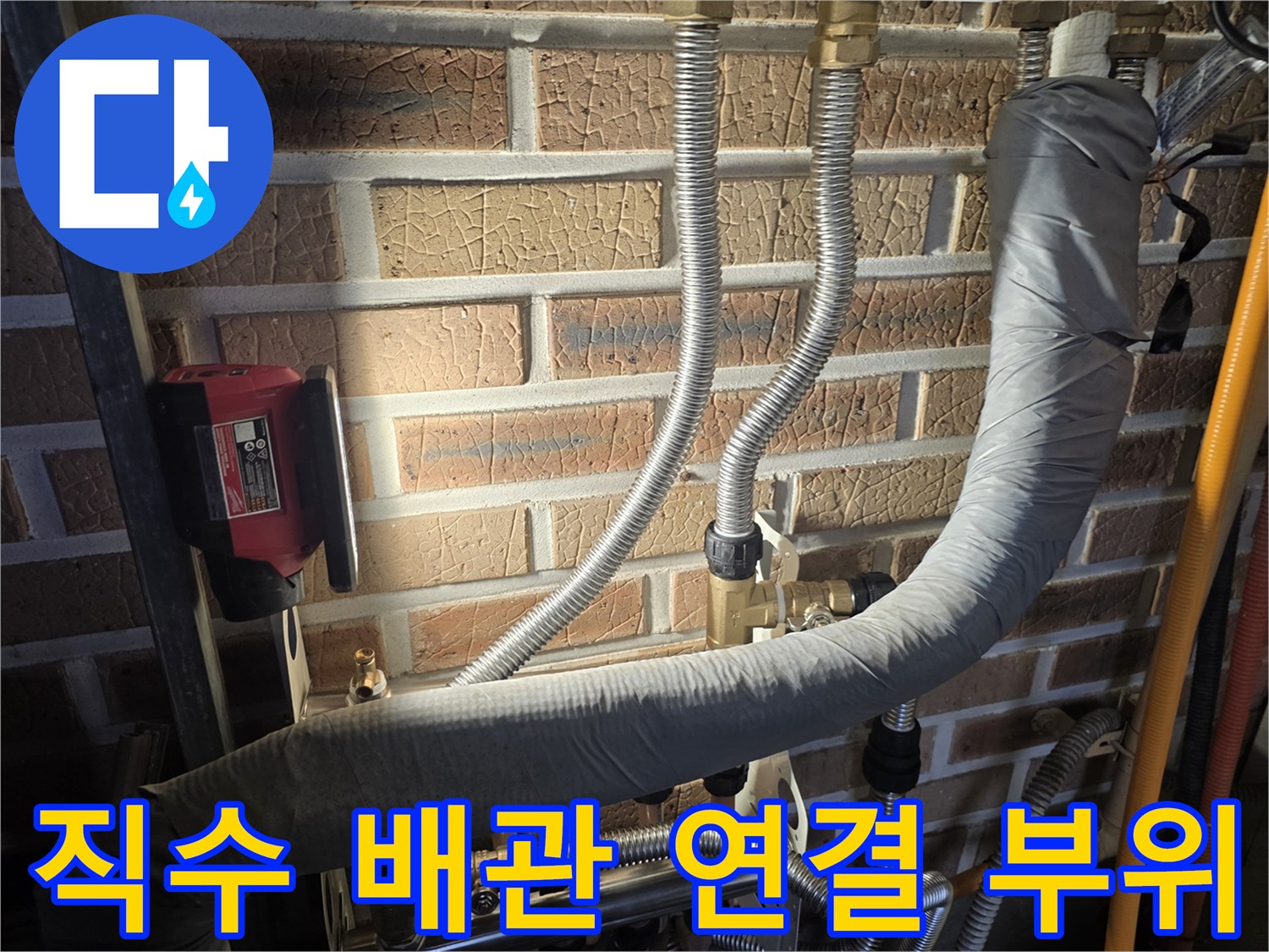 벽돌 구조물 옆에 설치된 보일러실 분배기 및 주름관 상세