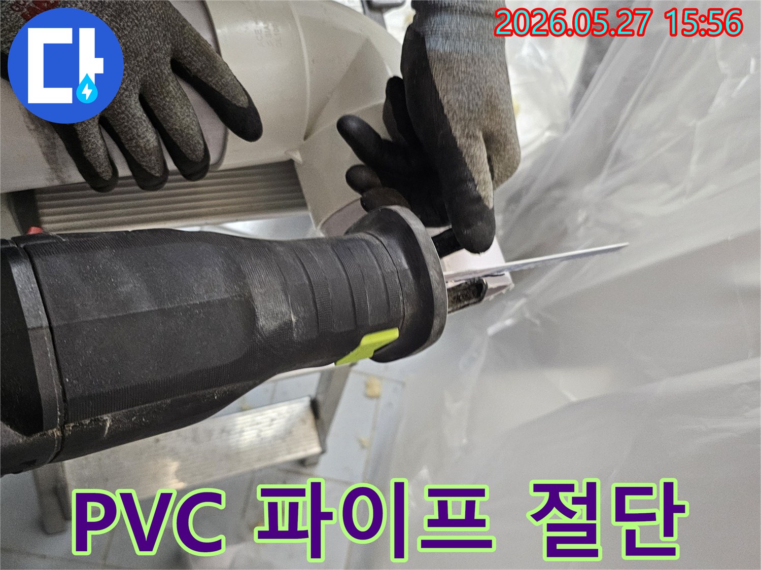 작업자가-안전장갑을-끼고-전동톱으로-오래된-PVC-파이프를-잘라내고-있습니다