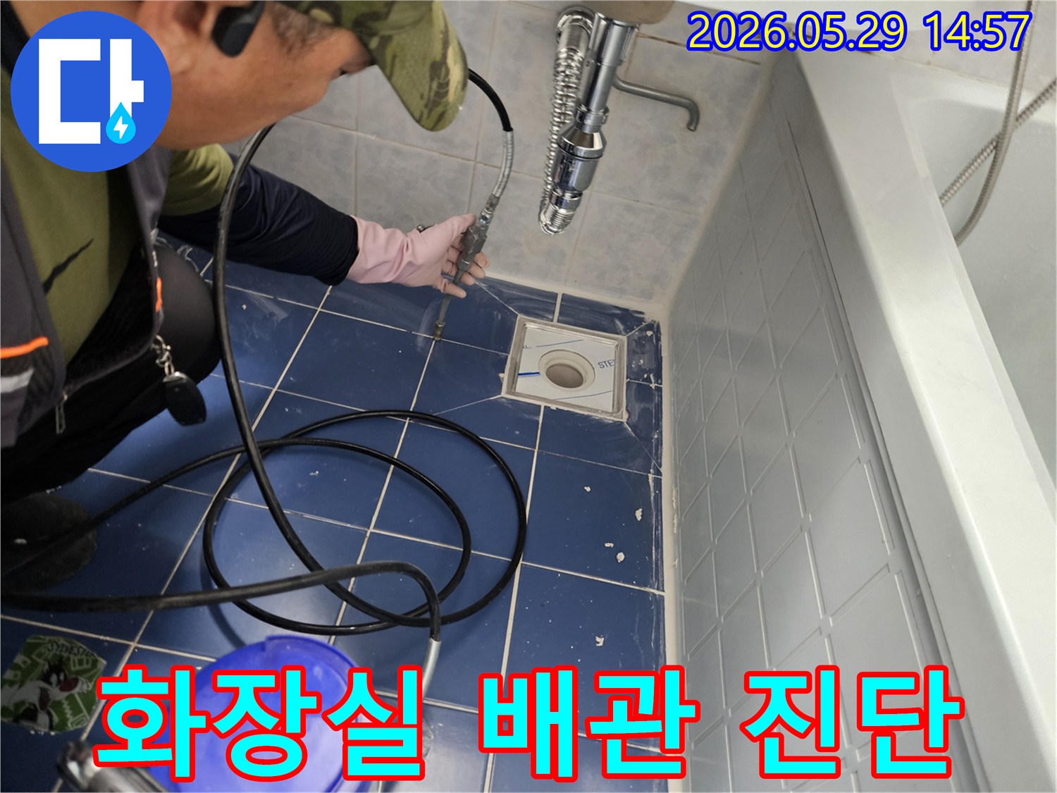 누수 전문 엔지니어가 욕실 바닥 배수구에 특수 장비를 삽입하여 화장실 배관의 누수 여부를 정밀하게 진단하는 모습입니다-전문가의 정확한 진단 과정입니다