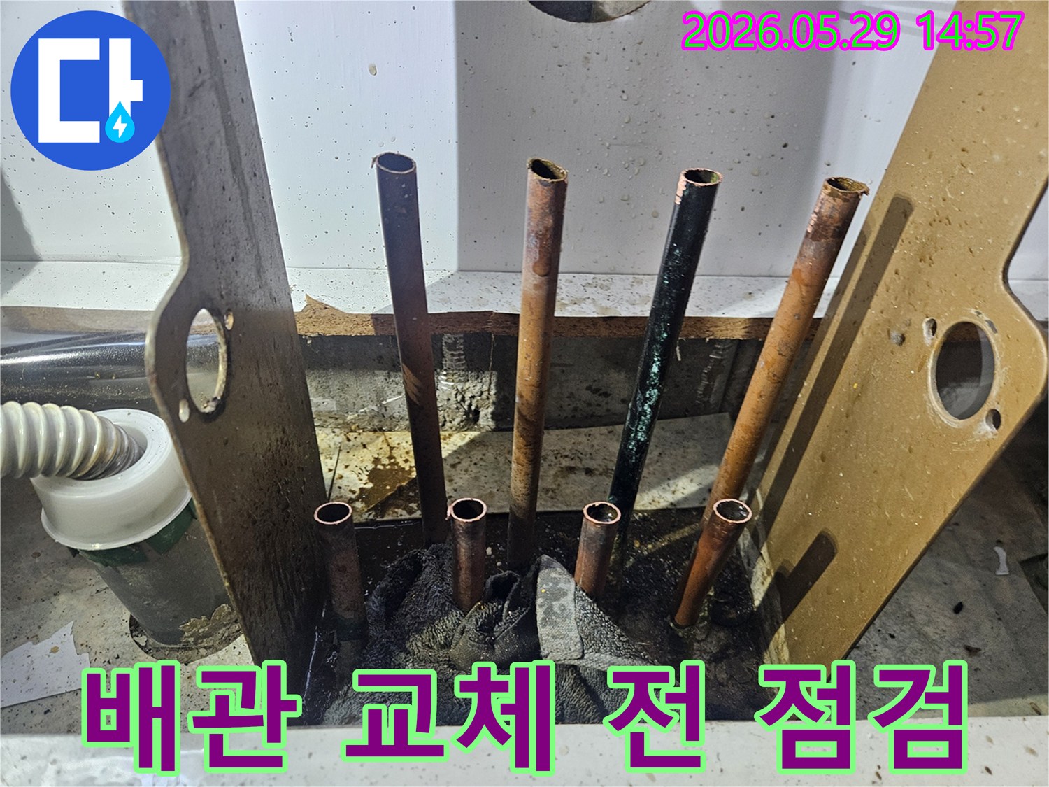 동두천 생연주공아파트 누수 공사 현장에서-바닥을 개방하고 노출된 배관의 교체 전 최종 상태를 점검하는 모습