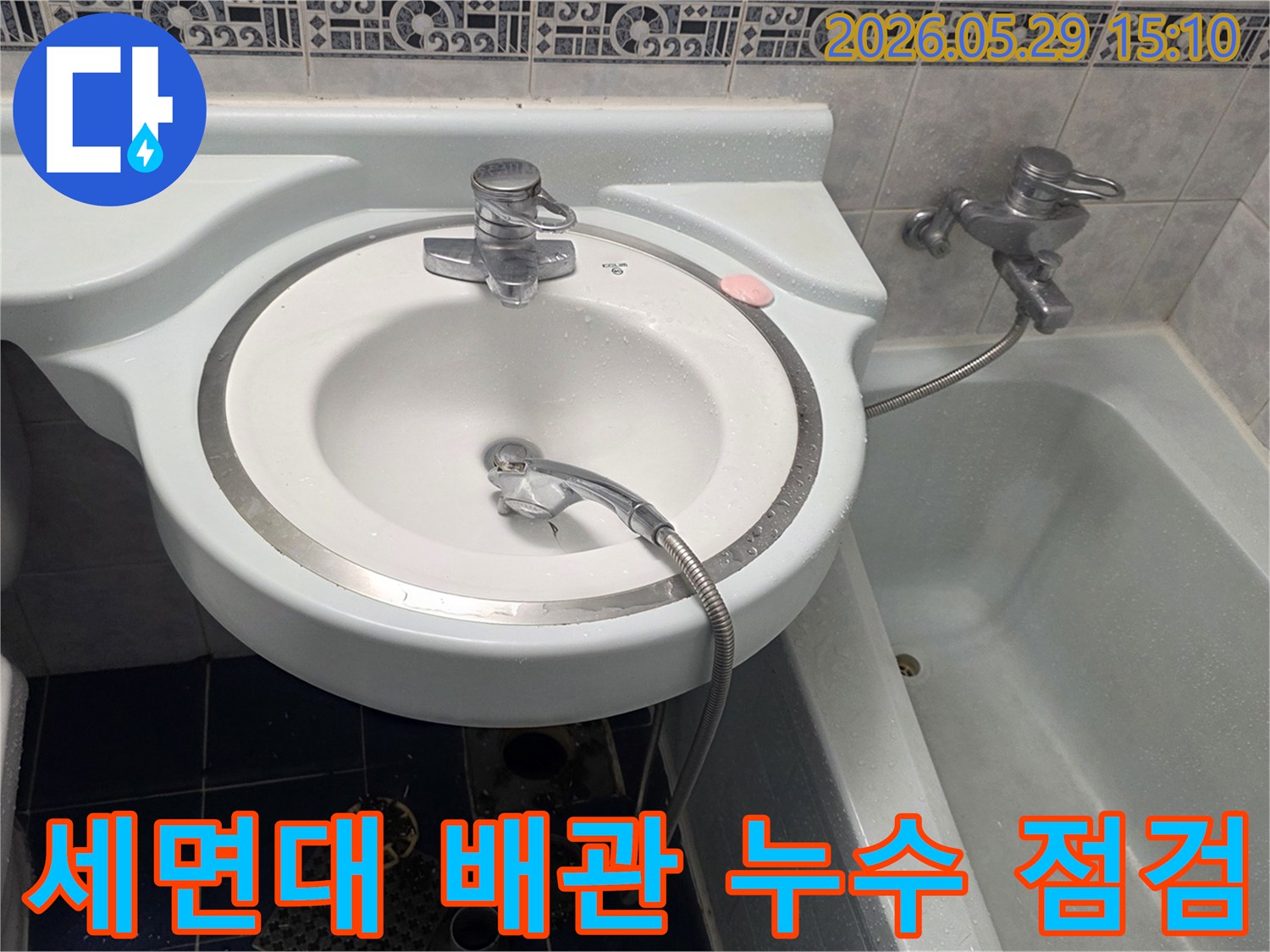 오래된 욕실 세면대 하부 배관에서-발생한 누수를-전문가가 정밀하게 점검하는 모습입니다.