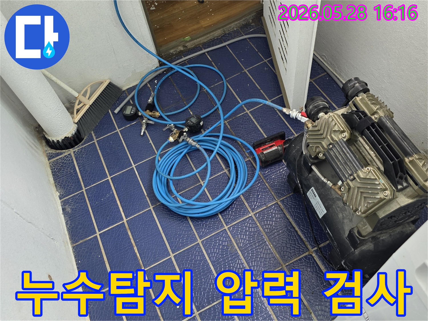 누수-원인을-찾기-위해-배관에-연결된-압력-측정-장비와-공압-호스-그리고-컴프레서가-보이는-작업-현장