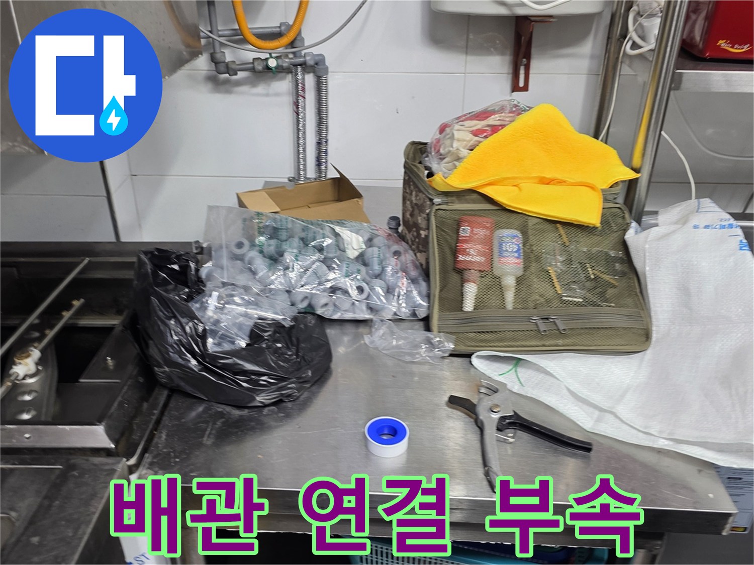 작업대 위에 정리된 배관 연결용 소모품과 공구들
