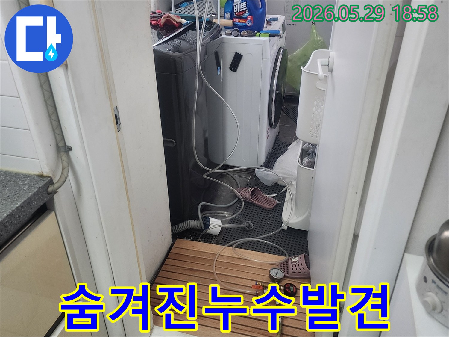 세탁실-배관에-연결된-압력-측정-장비를-사용하여-눈에-보이지-않는-숨겨진-누수-지점을-탐지하는-모습