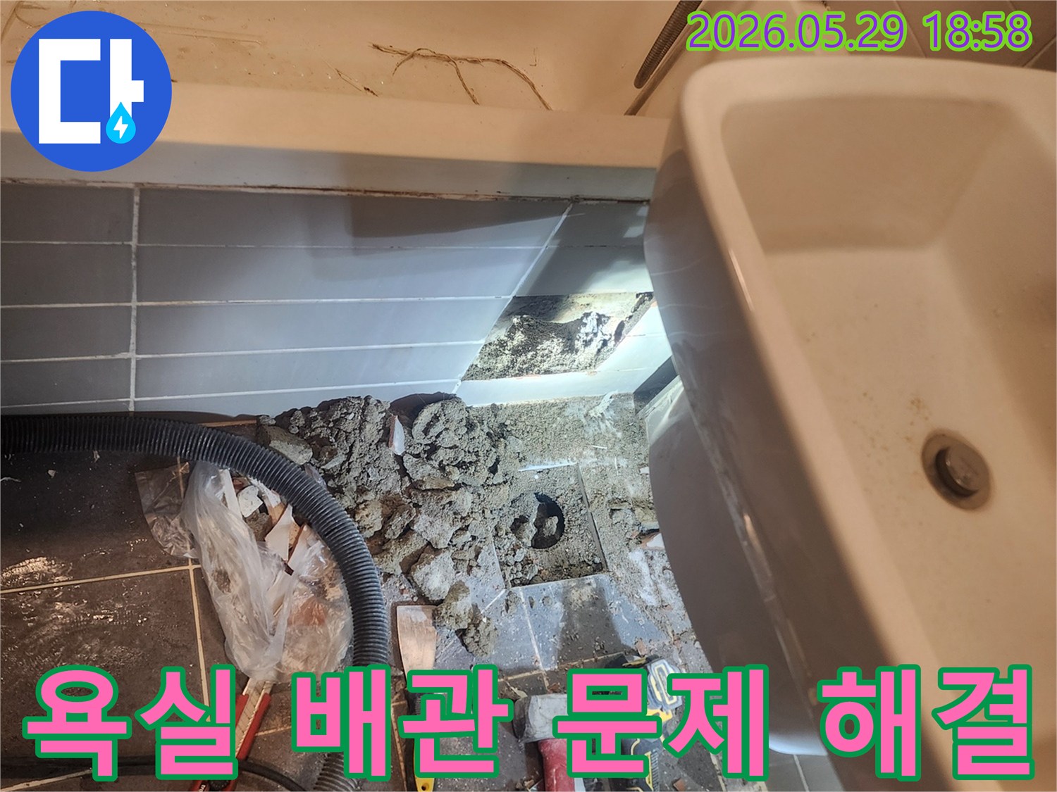 이 이미지는-성동구 금호동 아파트 욕실에서-누수 원인인 바닥 배관 문제를 해결하기 위해-타일을 제거하고-배관을 노출시킨-작업 현장을 보여줍니다