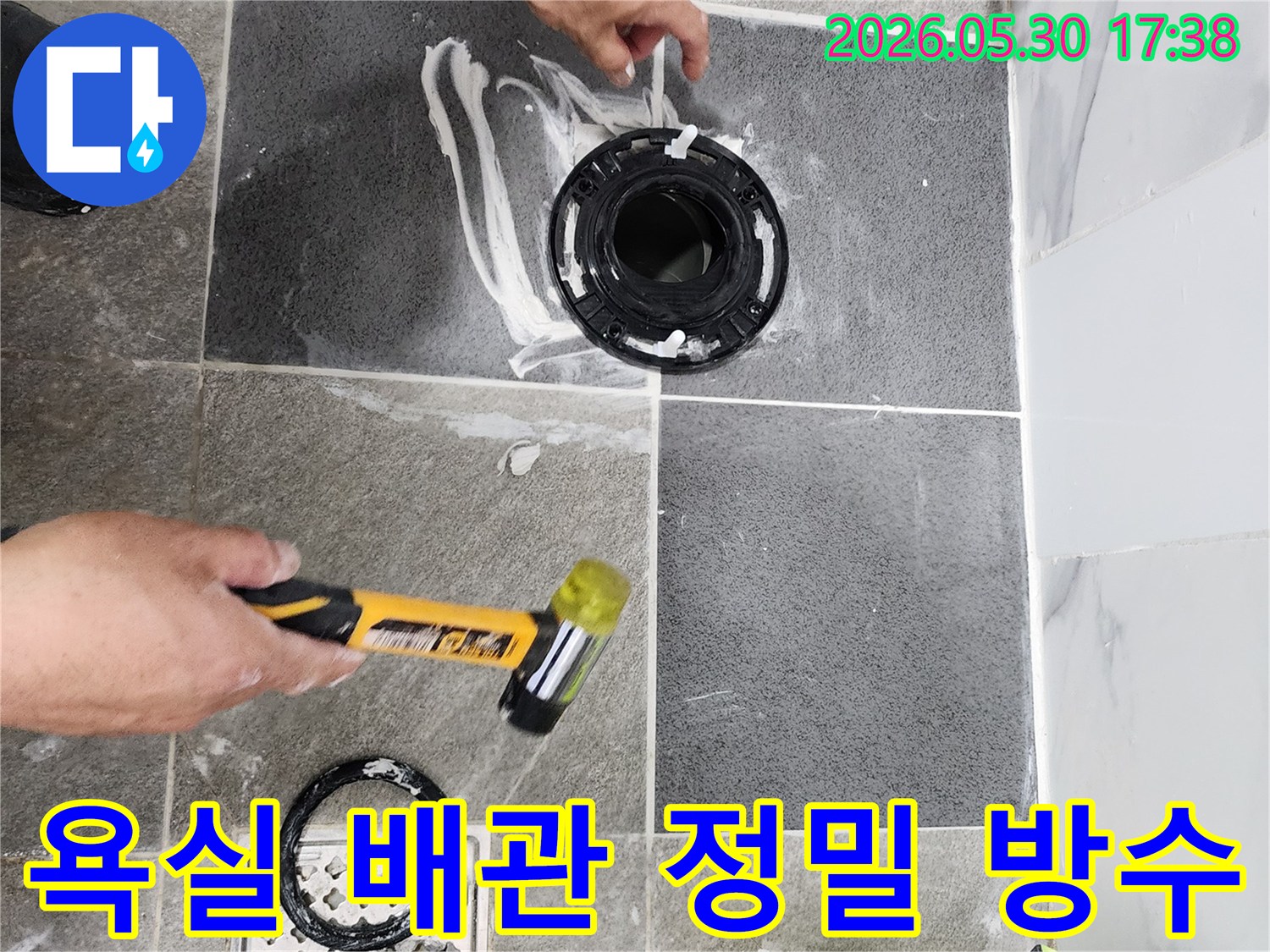 욕실 바닥의 배관 연결 부위와-변기 플랜지 주변에-누수 방지를 위한-특수 실란트 도포 작업이-전문가에 의해 진행되고 있습니다.