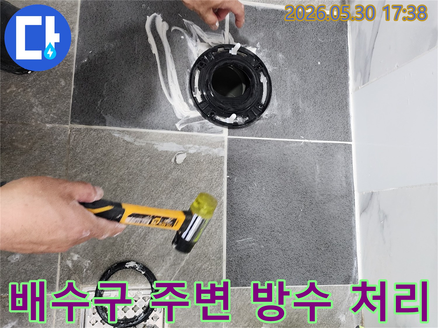 욕실 바닥의 배수구 주변과-변기 플랜지 연결 부위를-누수 방지를 위해-전문가가 꼼꼼하게 실링하고 있습니다.