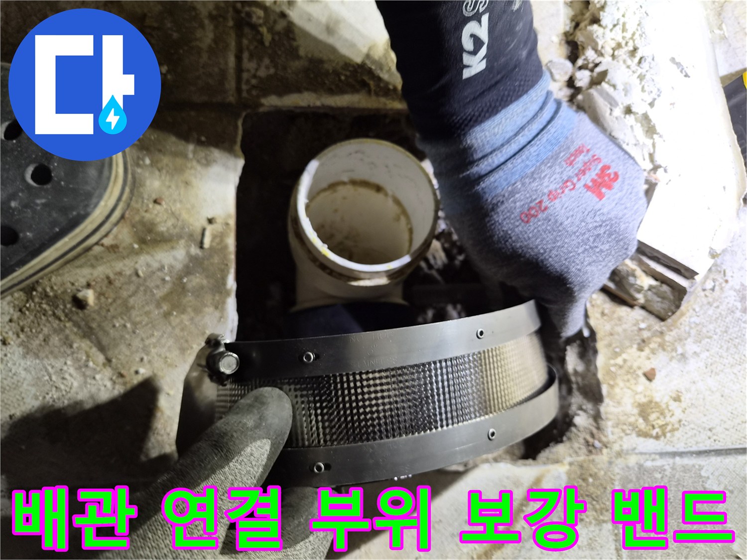 노후된 배관 연결부를 고정하기 위해 금속 밴드를 사용하는 장면