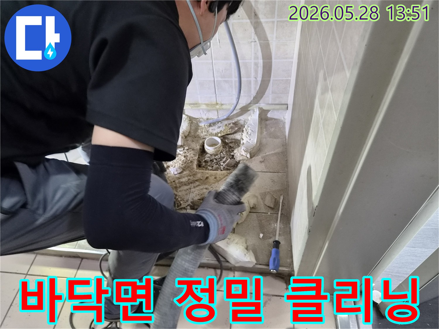 누수 공사 전문 기술자가-바닥 배관 수리 후-발생한 잔해물과 먼지를-흡입기로 정밀하게 청소하고 있습니다.