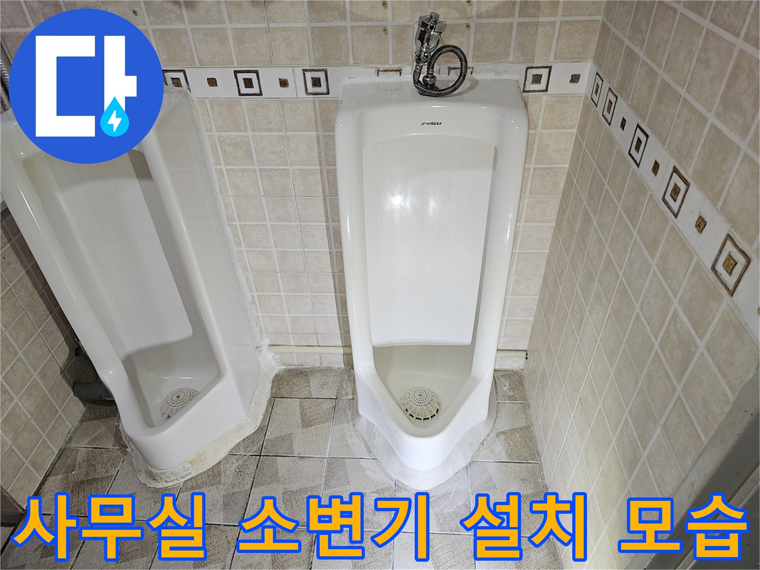 두 개의 소변기가 나란히 설치된 사무실 화장실 내부 전경입니다.