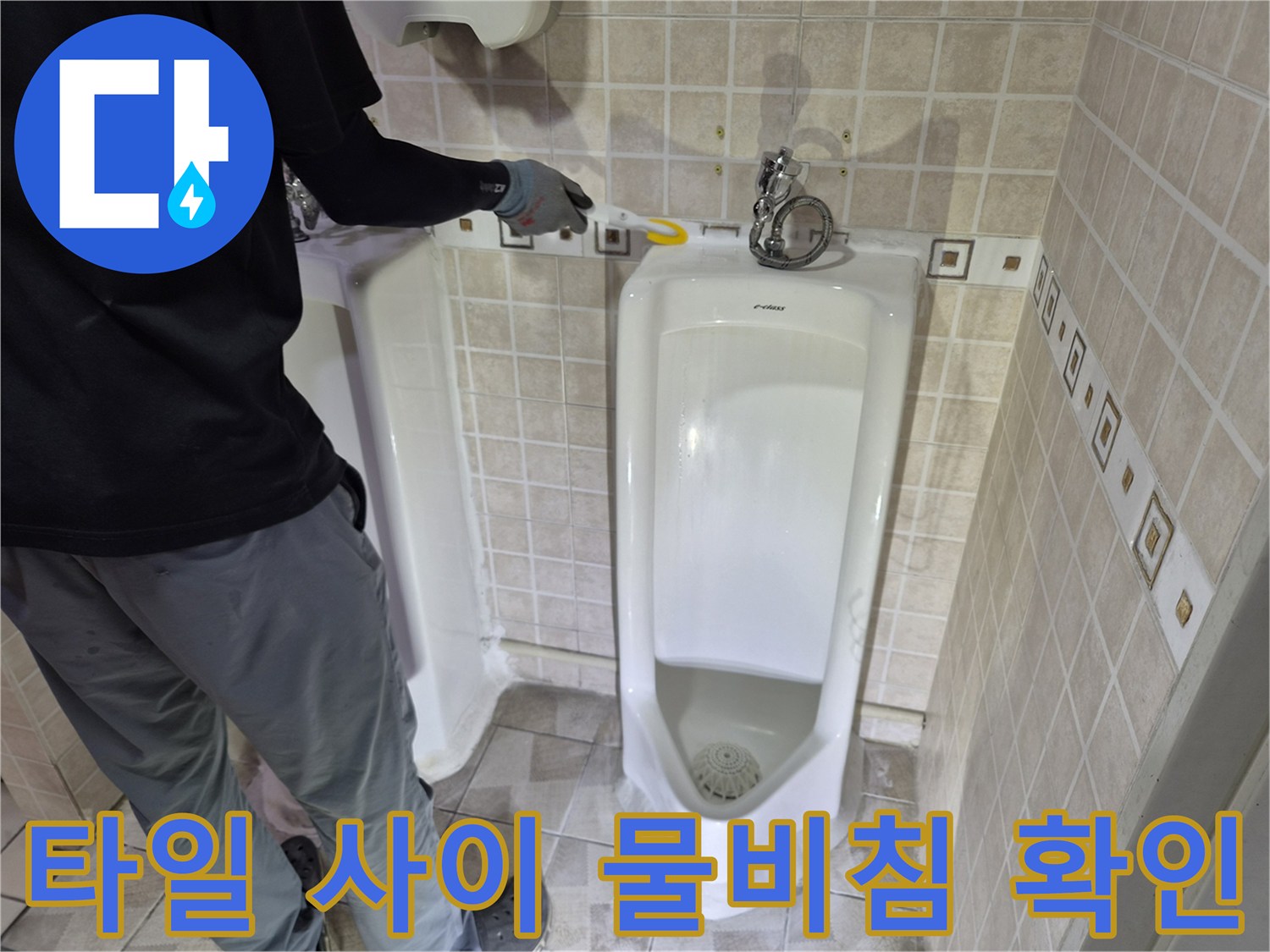 소변기 주변 타일 줄눈에 습기가 맺혀 있는 현장을 보여줍니다.