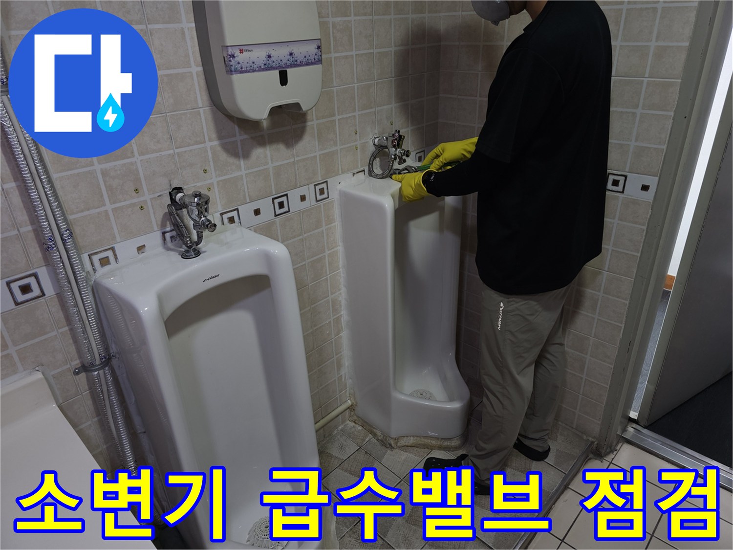 양천구 사무실 현장에서 엔지니어가 소변기 벽면 급수 밸브 부위를 점검하고 있습니다.