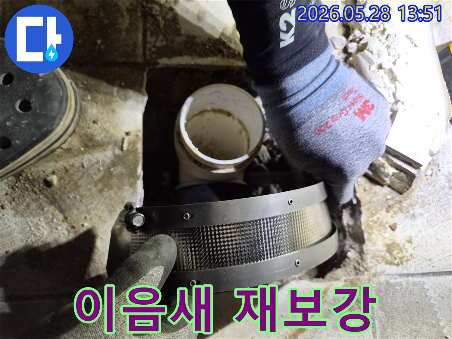 작업자가 안전 장갑을 착용하고-아파트 배관의 이음새 부분을-특수 보강 밴드로 다시 감싸는 모습입니다