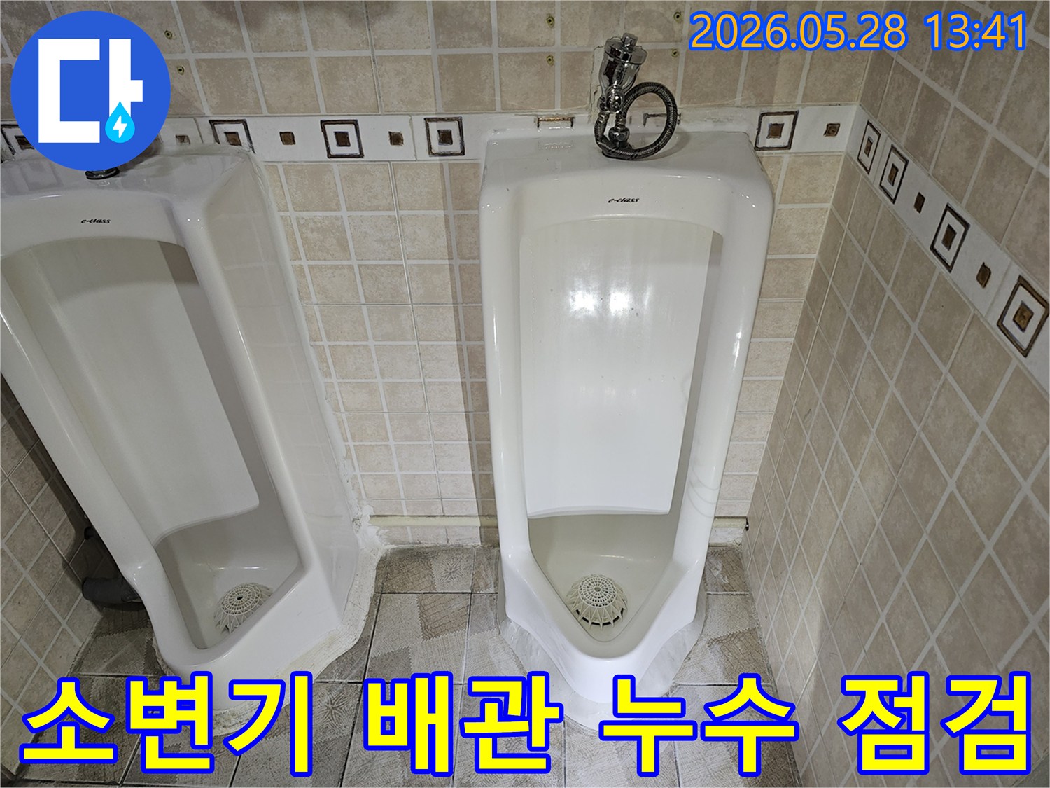 화장실 소변기 하수 배관에서-누수가 발생하여-전문가가 육안으로 확인하고 있는 장면입니다.