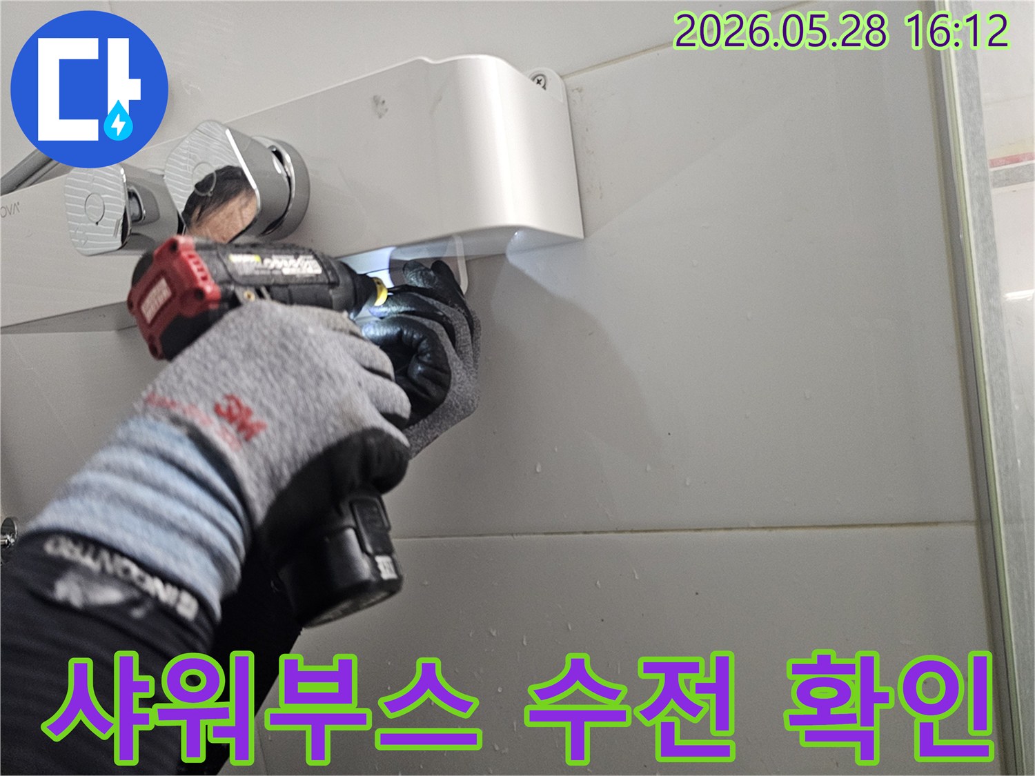 숙련된 기술자가-보호 장갑을 착용하고-전동 공구로-샤워부스 수전의-연결 부위를-정밀하게-점검하는-작업 현장입니다