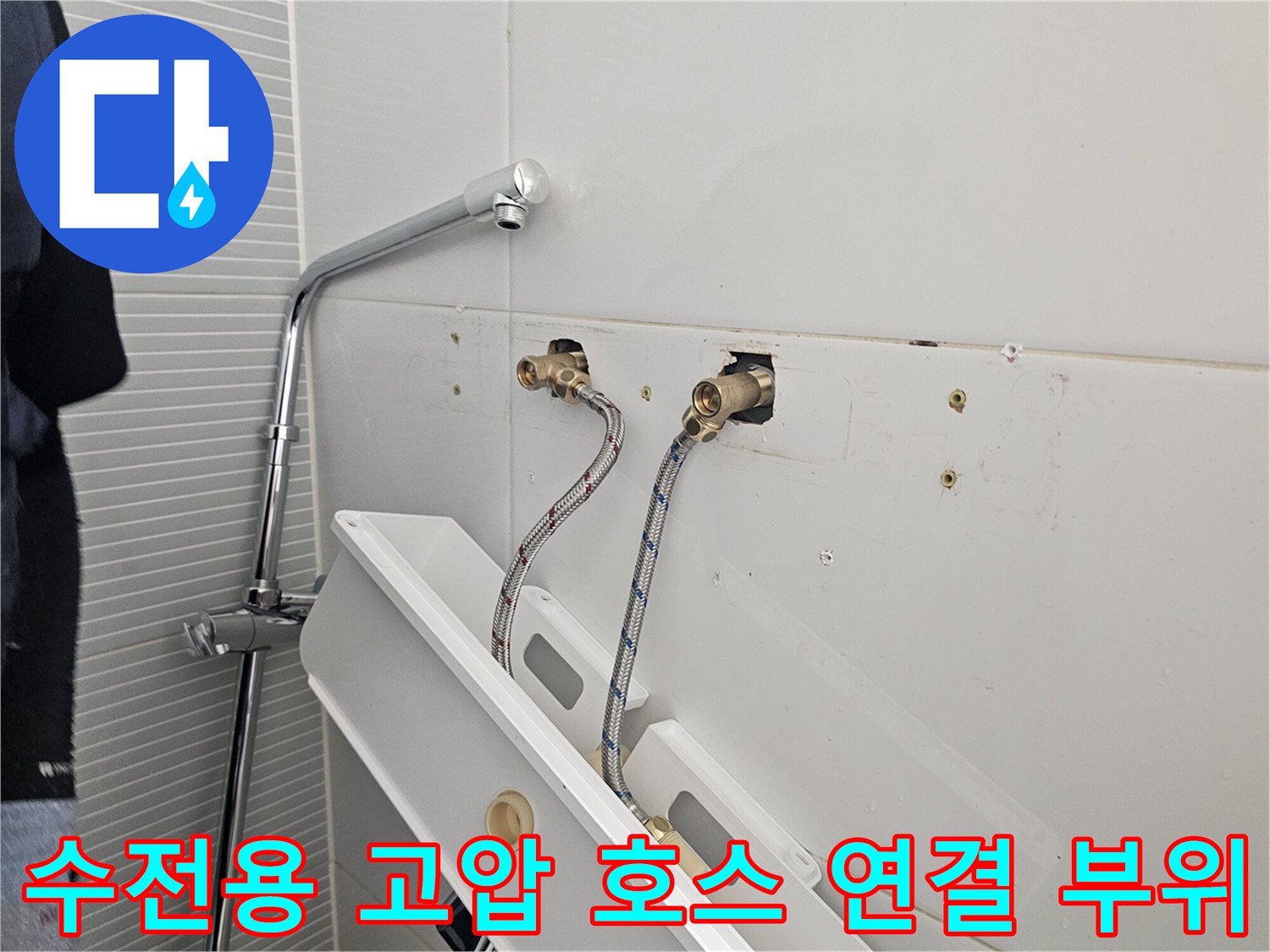 욕실 벽면에 노출된 냉온수 배관과 고압 호스의 모습