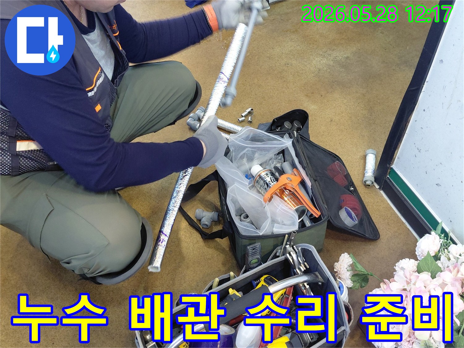 누수 수리 현장에서-엔지니어가 배관을 연결하기 위해-다양한 공구를 준비하는 모습입니다.