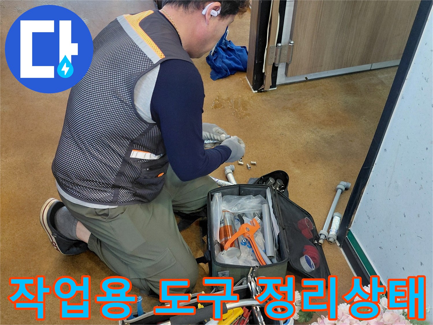 배관 수리를 위해 작업자가 준비한 공구 가방과 장비들입니다.