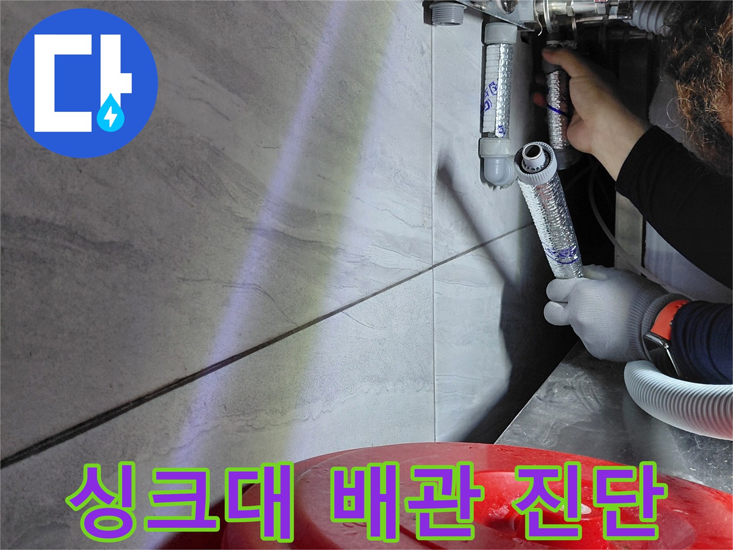 배관 연결 부위의 누수 여부를 확인하기 위해 조명을 비추는 작업 모습
