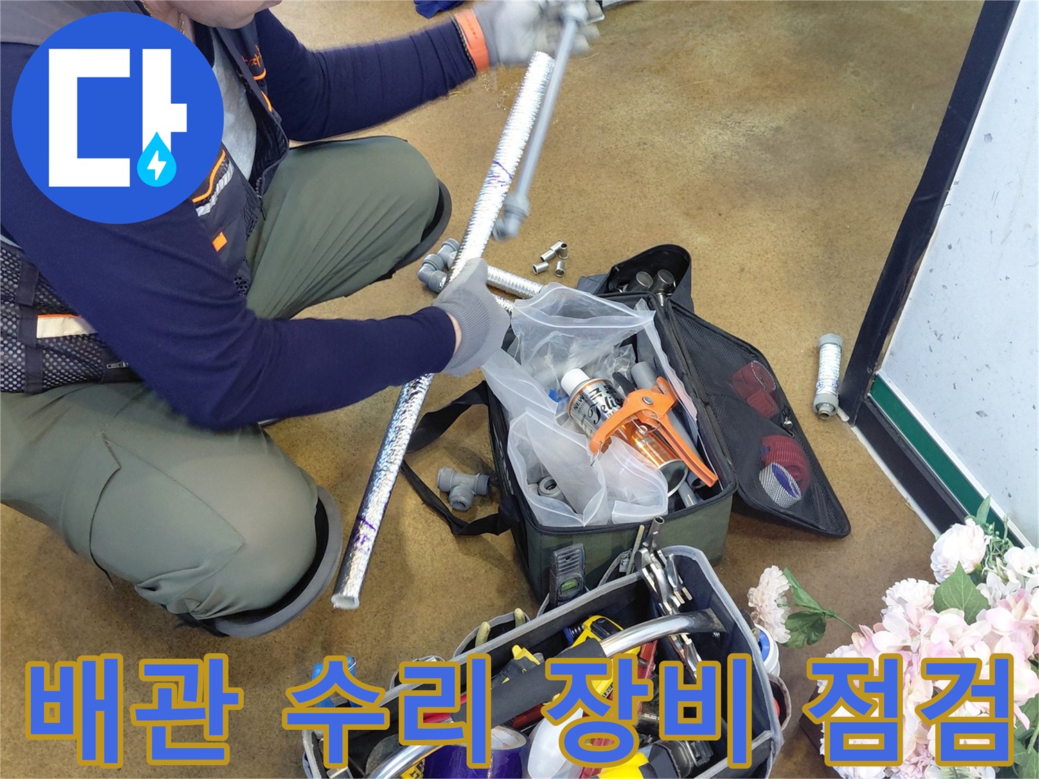 주방 하부 배관 수리를 위해 준비된 전동 드릴과 각종 공구 세트