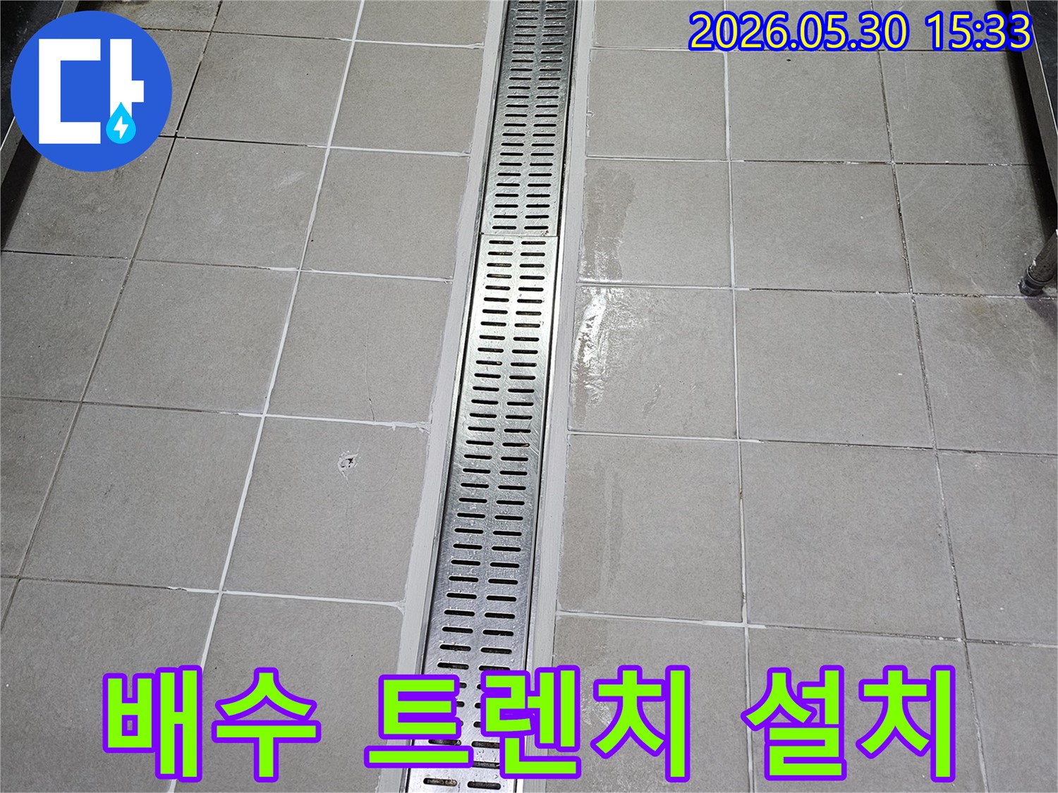 새롭게 시공된-길고 얇은-스테인리스 배수 트렌치-타일 바닥과-벽면에 조화롭게 설치된 모습