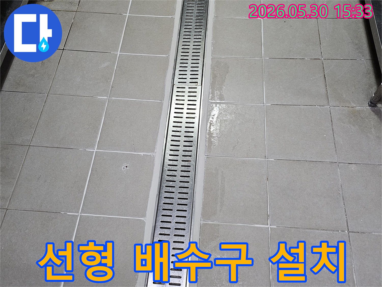 타일 벽면에-새롭게 시공된-스테인리스 선형 배수구-물이 효율적으로-배수되도록 설계된 모습