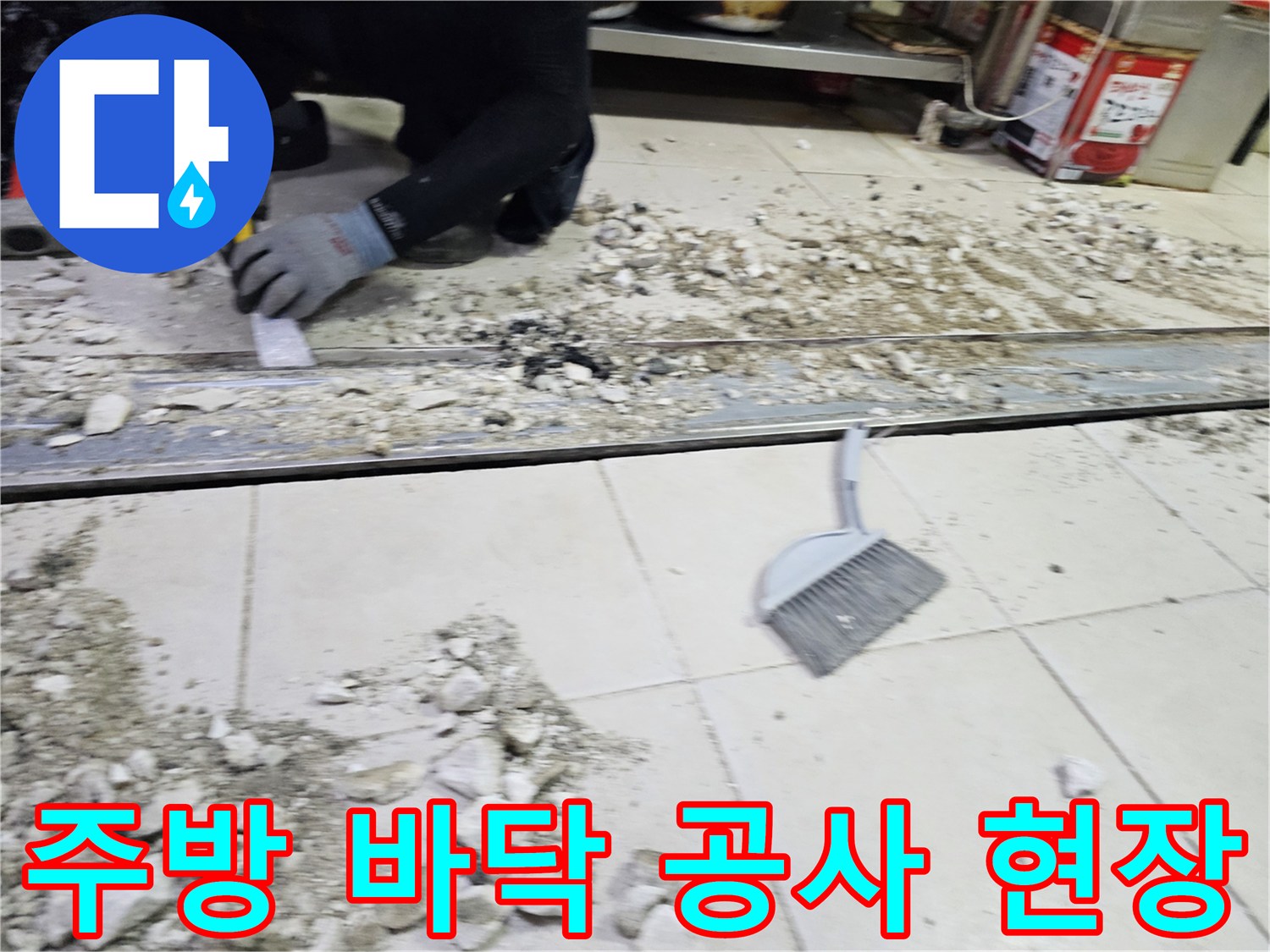 트렌치 주변의 타일과 시멘트 덩어리가 제거된 식당 주방 내부 모습입니다.