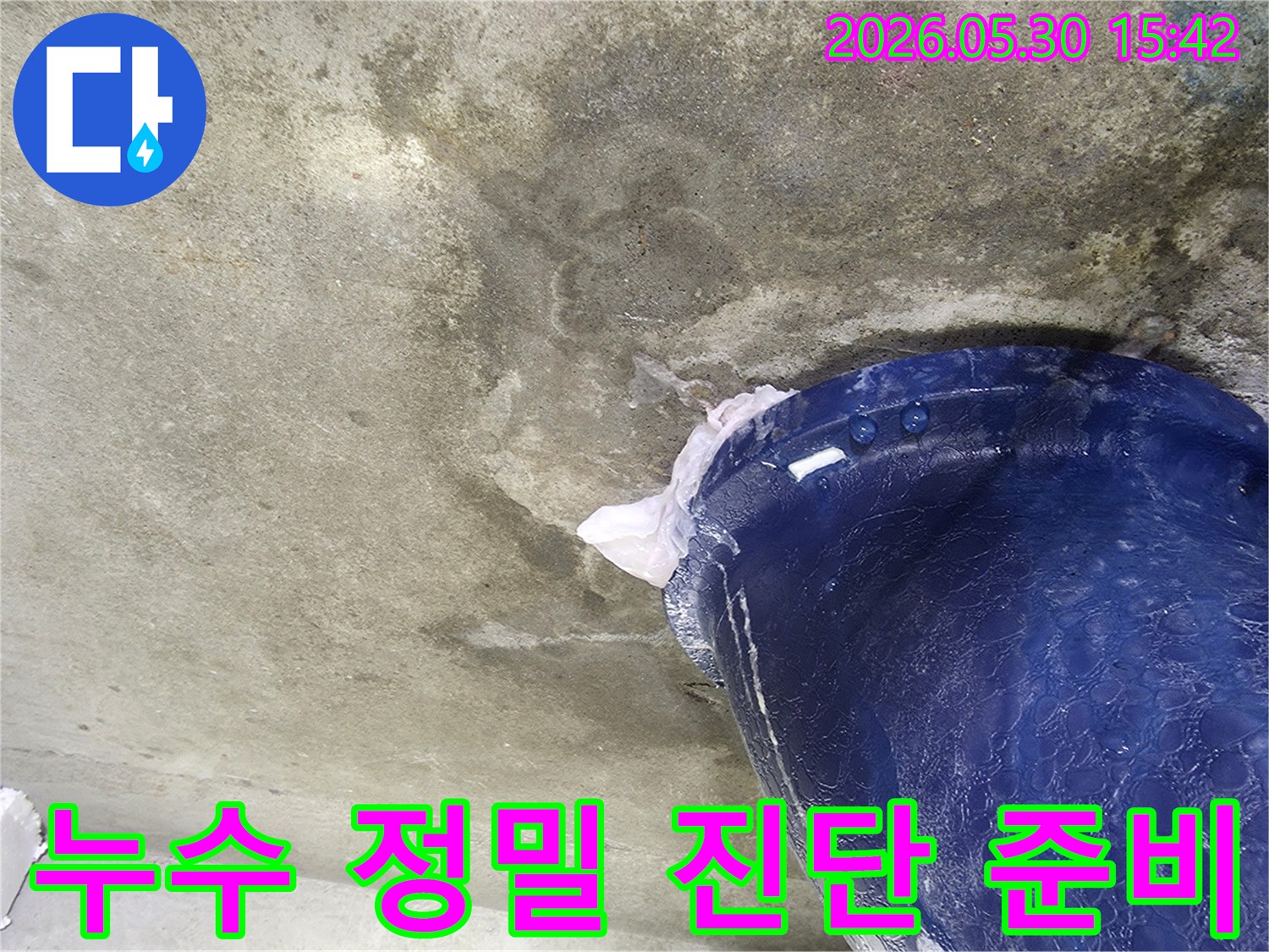 천장에서 물이 떨어지는 현장에서-정밀 진단을 시작하기 전-파란색 양동이를 설치하여-물을 받아내는 모습입니다.