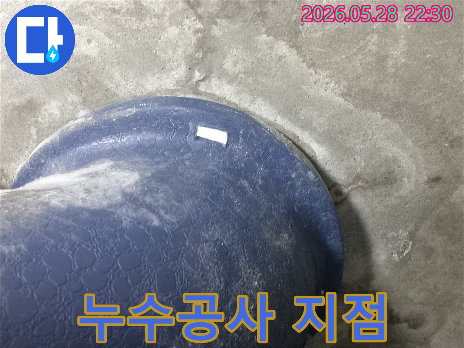 콘크리트 바닥의-파란색 배관-주변으로-물이-새어-나와-젖은-모습을-보여주는-누수-공사-예정-구간-사진