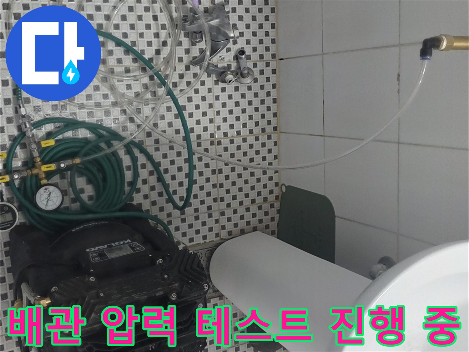 세면대 하부 배관에 연결된 공압식 검사 장치와 호스