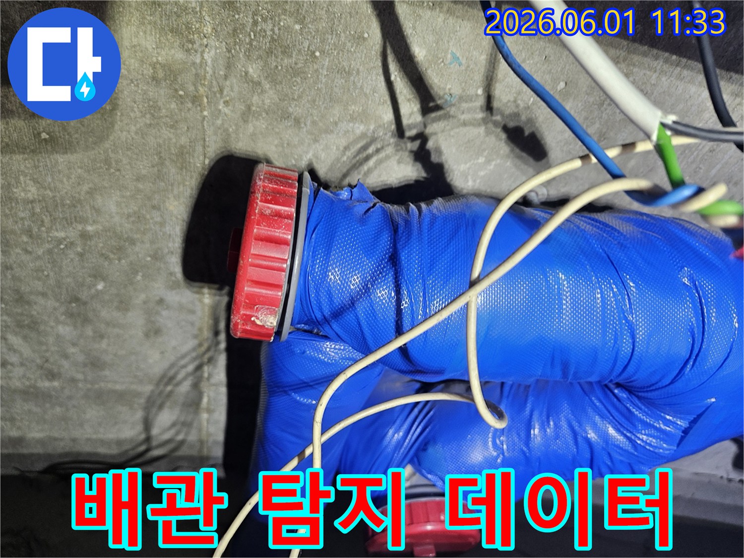 누수 공사 현장에서-배관에 연결된 탐지 장비로-데이터를 분석하는 모습입니다.