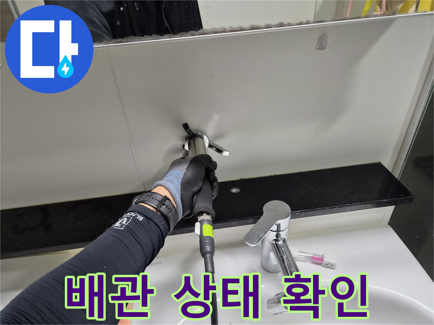 벽면 틈새로 드러난 배관의 파손 부위를 찾기 위해 집중하는 작업자입니다.