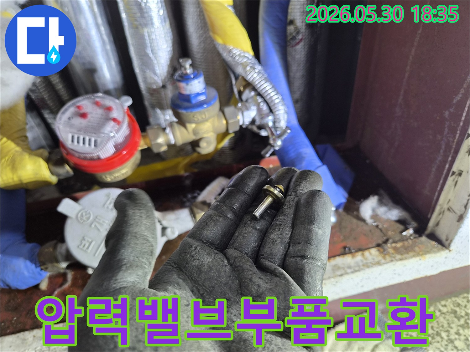 상가-건물-누수-현장에서-발견된-압력-조절-밸브-내부-부품을-작업자가-검토하는-모습