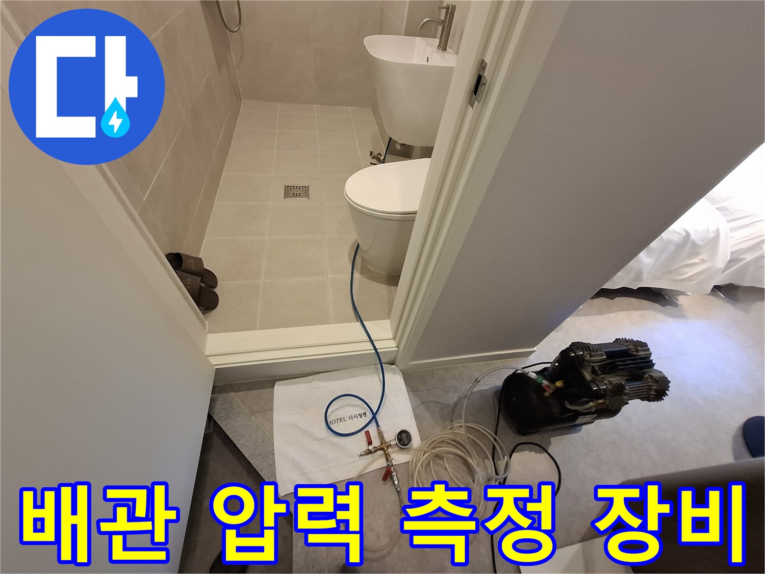 욕실 입구 바닥에 설치된 배관 내부 압력 체크용 정밀 게이지와 호스