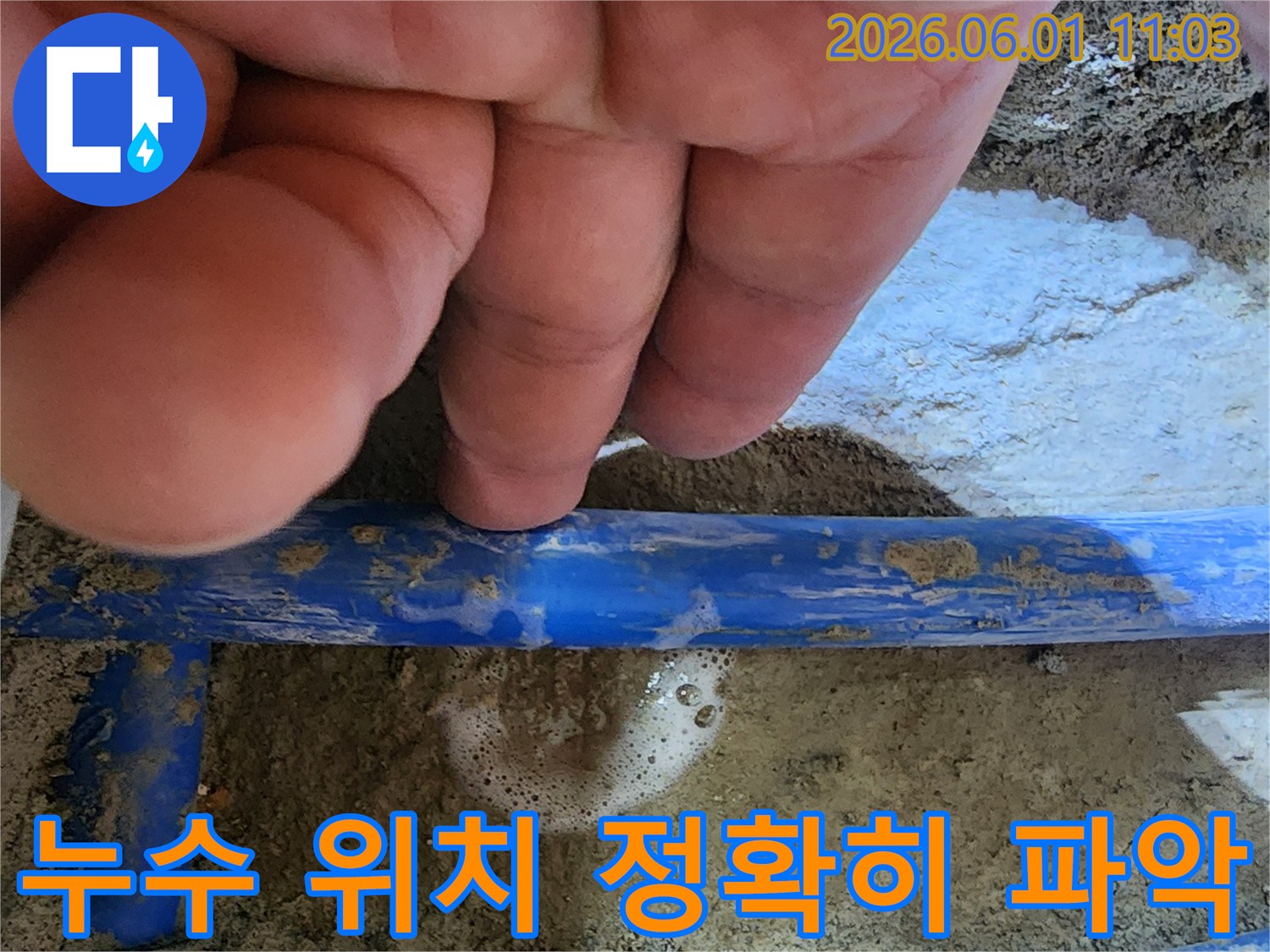 엔지니어의 손가락이-파란색 배관의-누수 지점을 가리키며-거품으로 누수를-확실히 보여주는 사진