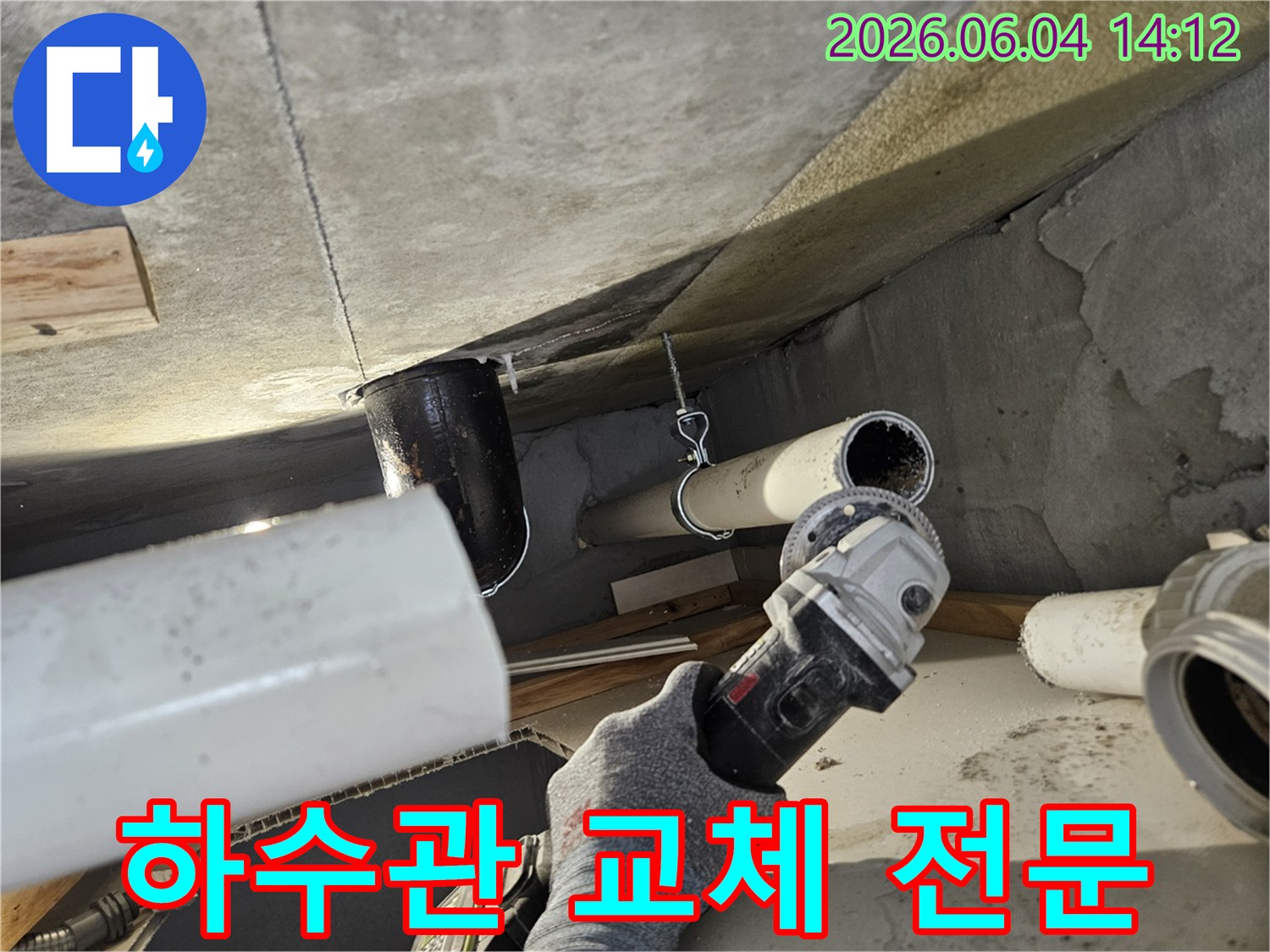 누수된 하수관을 교체하기 위해 그라인더로 절단하는 전문 기술자의 작업 모습