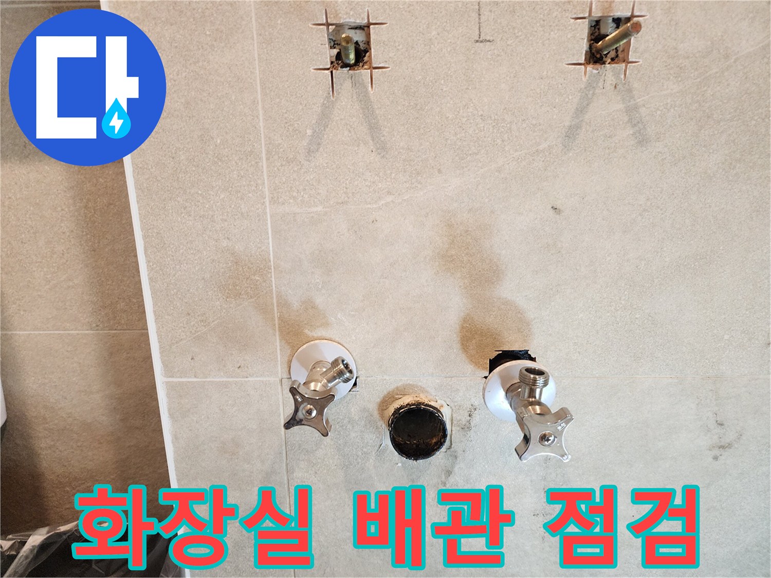 욕실 벽면에 설치된 앵글밸브와 노출된 배관 부속의 모습