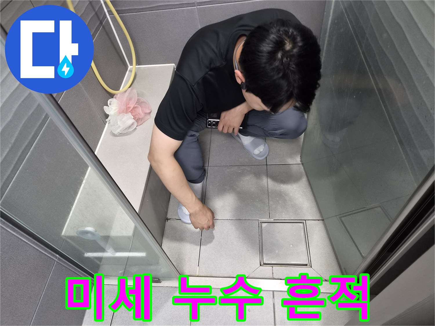 강동구 천호동 욕실에서-전문가가 손끝으로 바닥 타일과 줄눈의-미세한 누수 흔적을 감지하며-원인을 파악하는 모습