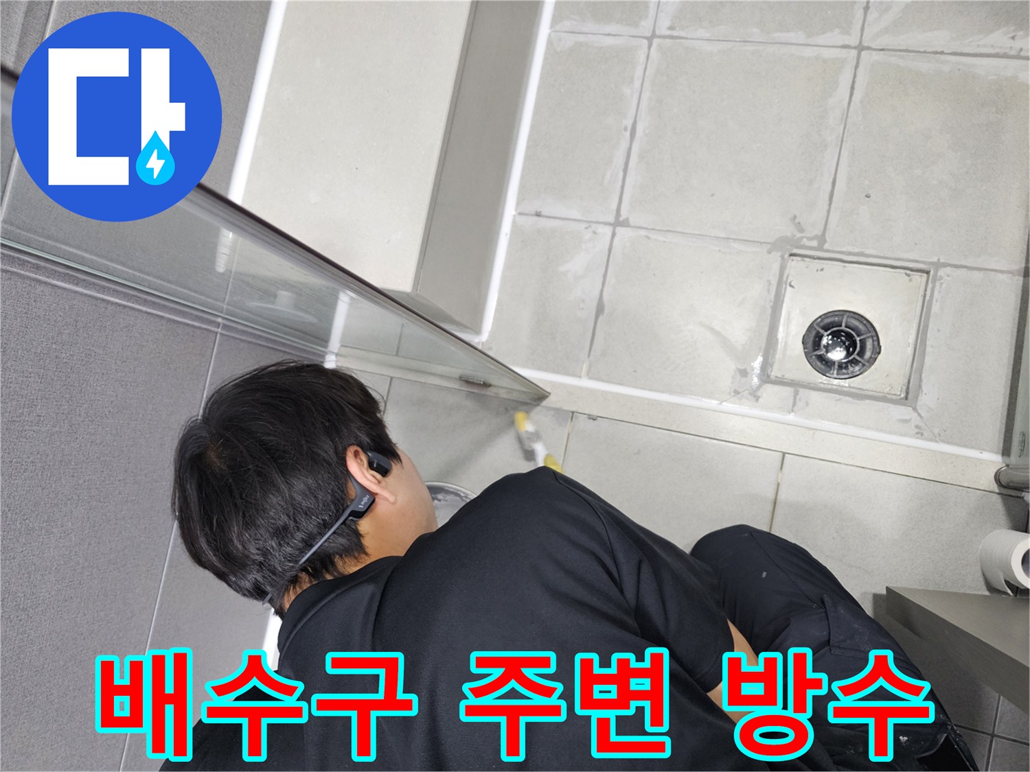 누수-엔지니어가-샤워실-배수구-주변의-취약한-틈새를-고품질-방수재로-꼼꼼하게-처리하는-모습