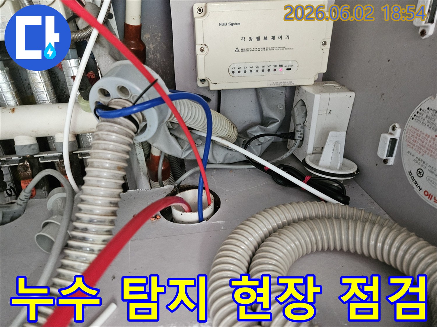 각방 밸브 제어기 아래 배관과 전선이 얽힌 곳에서 누수 여부를 점검하는 모습입니다.