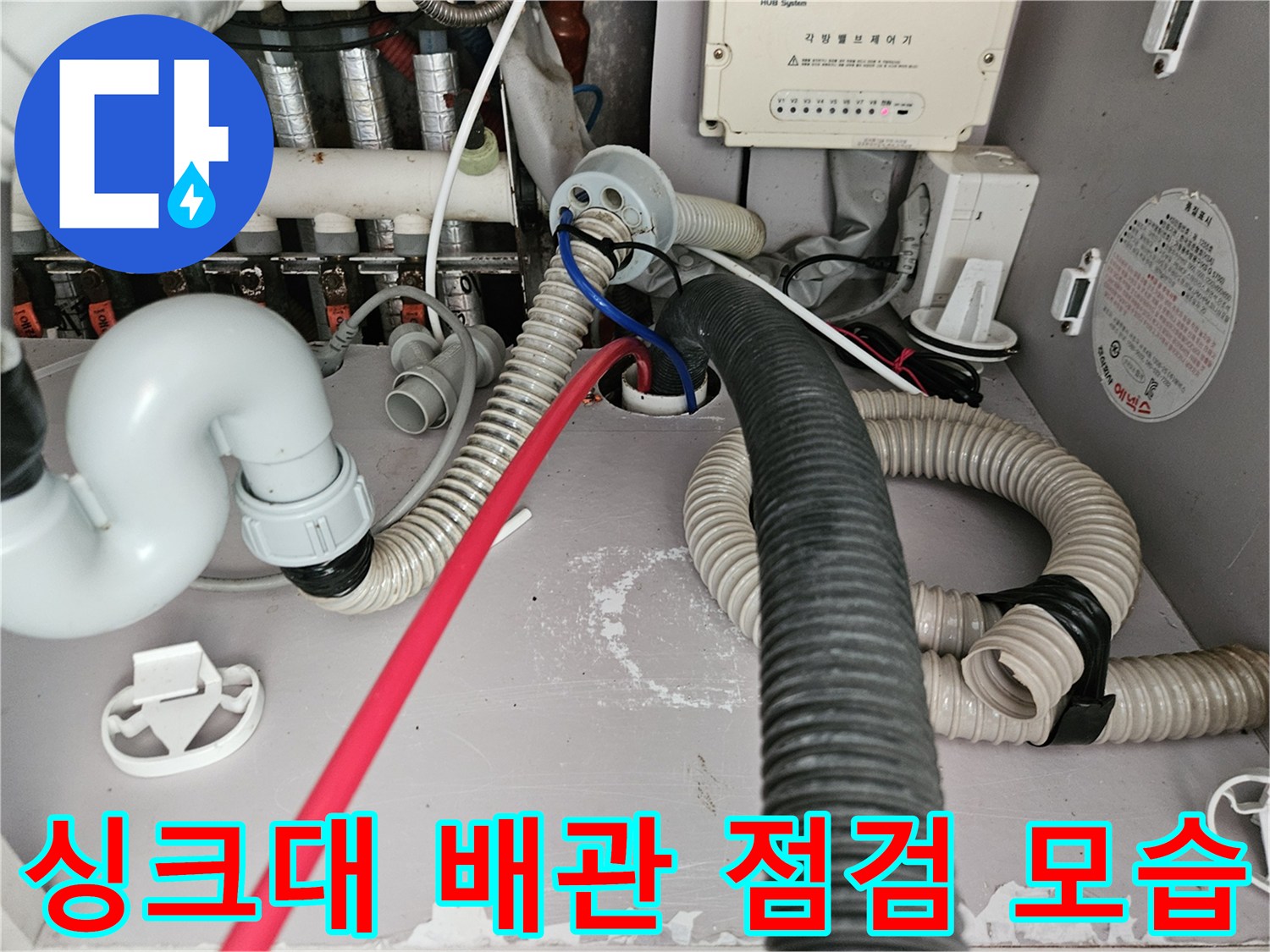 김포 한강동 싱크대 하부장 내부의 복잡한 배관과 호스 상태를 보여주는 사진입니다.