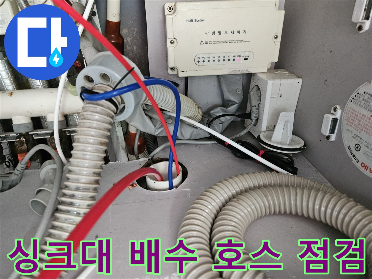 싱크대 하단부의 굵은 주름관과 전기 장치 연결 부위